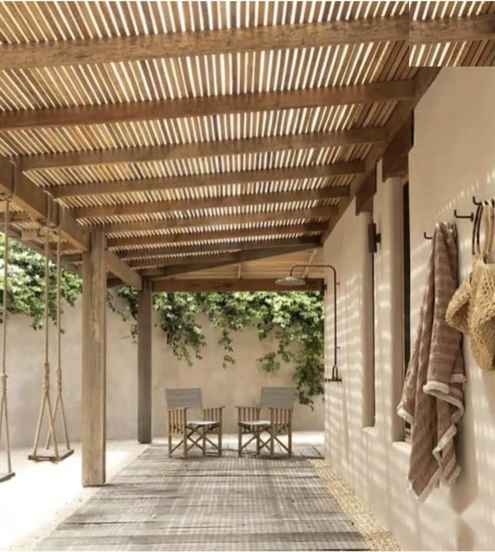 Porche con pérgola de listones de madera, columpio y ducha exterior